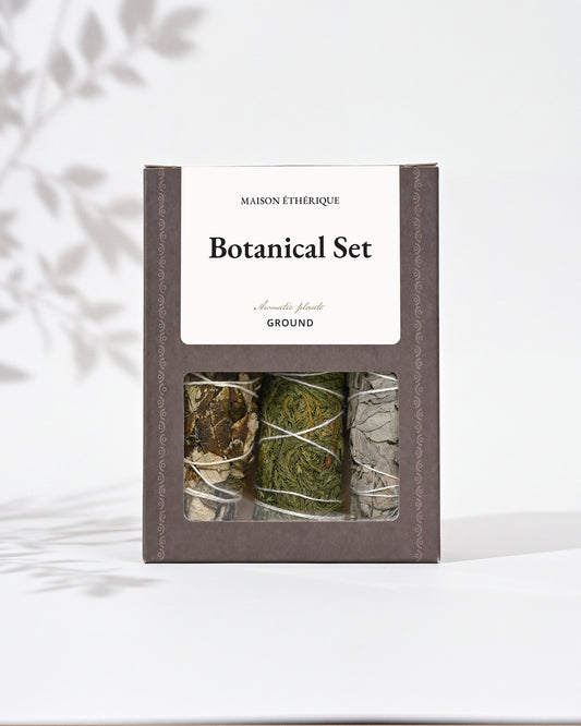 Botanical Set — Ground: grey-brown Maison Éthérique box with a window showing three bundles of white sage, cedar and yerba santa.