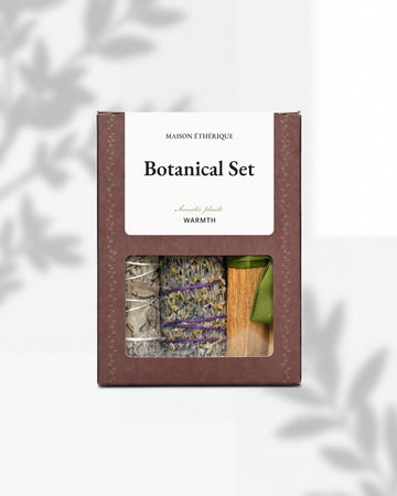 Botanical Set — Warmth: brown Maison Éthérique box with a window showing white sage, lavender and Palo Santo tied with green ribbon.