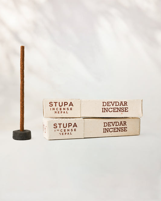Devdar incense sticks, tube of 15: two Stupa paper boxes beside a stick standing in a small holder.