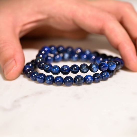 2 kyanite bracelet being placed on table