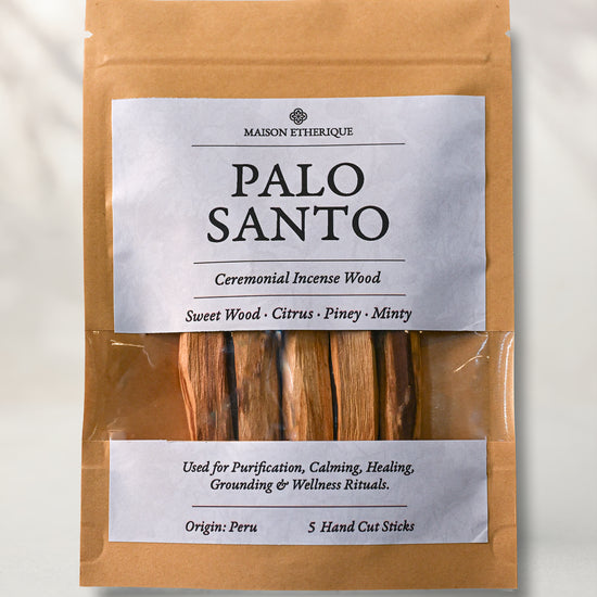 Front of a kraft pouch of Maison Éthérique Palo Santo, five hand-cut sticks visible through a clear window, on a pale background.