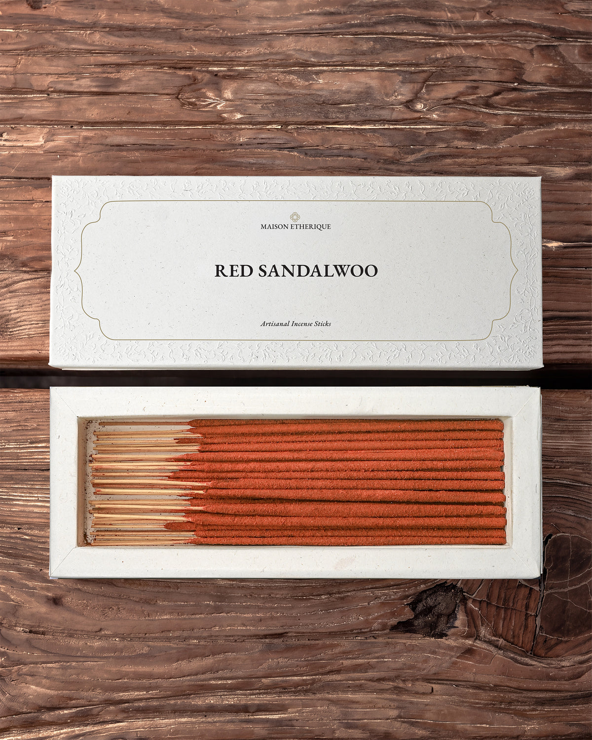 Red Sandalwood incense sticks: Maison Éthérique white box lid above the open box of red-brown sticks, on a wooden surface.