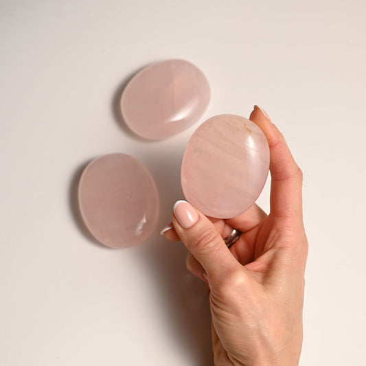 Hand holding a rose quartz stone