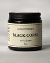 Amber glass jar of Maison Éthérique Black Copal from Peru, black lid, on a pale background.