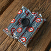 Three foil-wrapped rolls of charcoal tablets with one loose tablet on top, on a wooden surface.