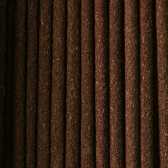 Close view of Dorjee incense sticks laid side by side, showing their dark brown texture.