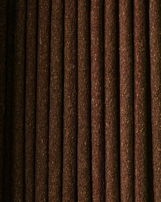 Close view of Dorjee incense sticks laid side by side, showing their dark brown texture.