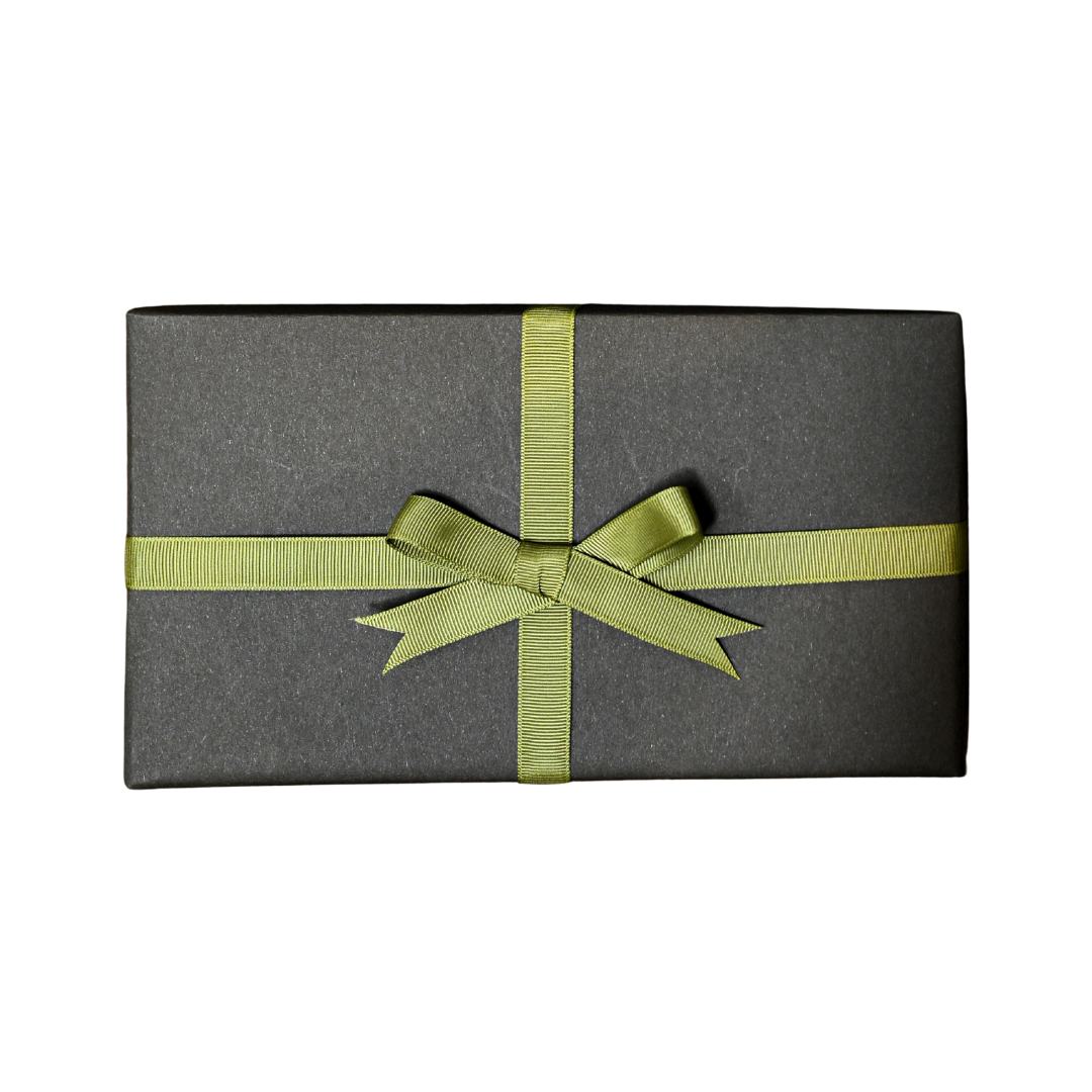 Gift wrapped in dark grey paper and tied with a green ribbon bow, on a black background.