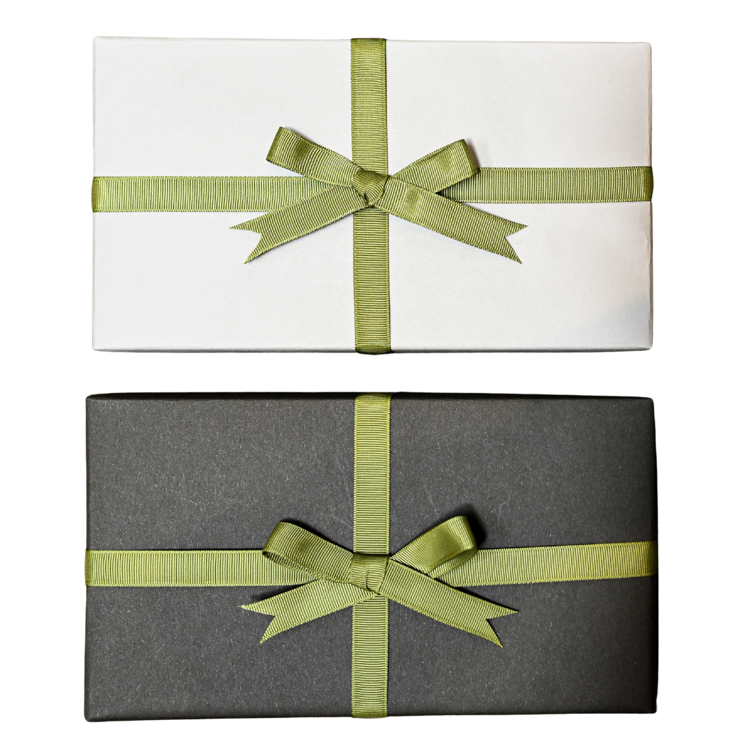 Two wrapped gifts, one in white paper and one in dark grey, each tied with a green ribbon bow, on a black background.