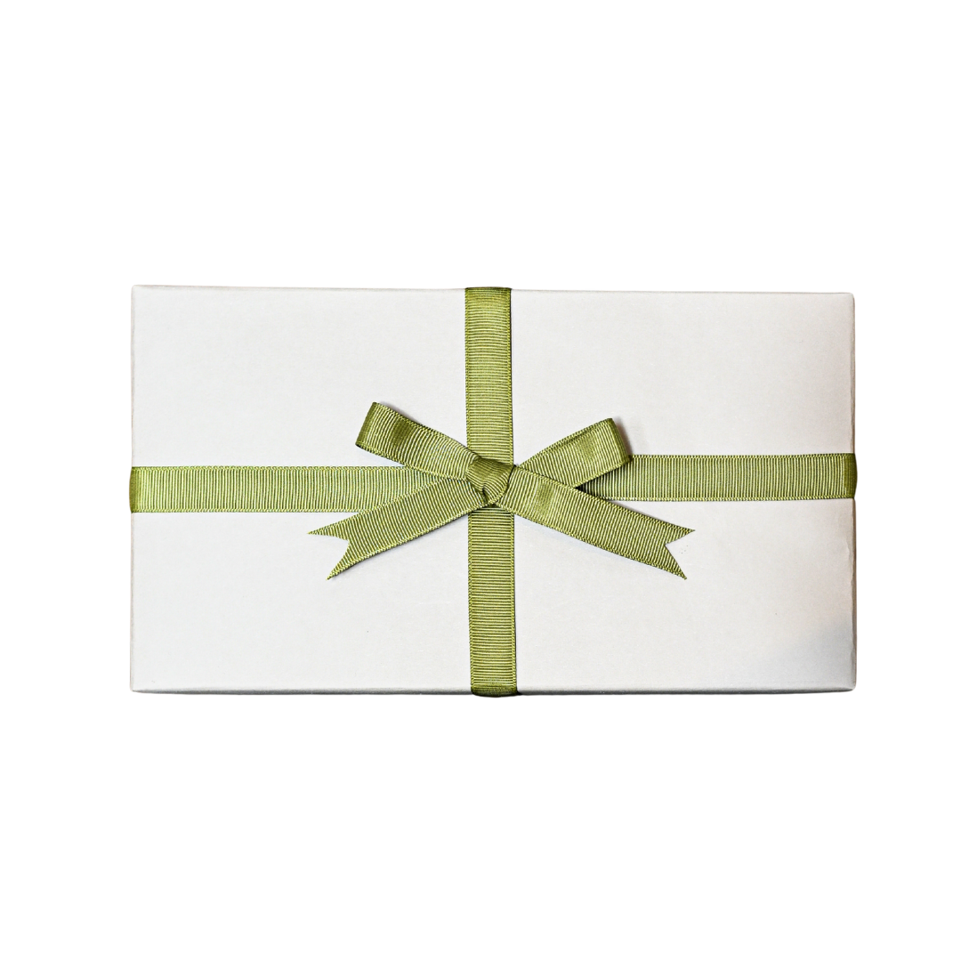 Gift wrapped in white paper and tied with a green ribbon bow, on a black background.