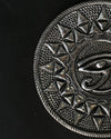 Close view of the Eye of Horus metal incense holder, showing the embossed eye and triangular border.