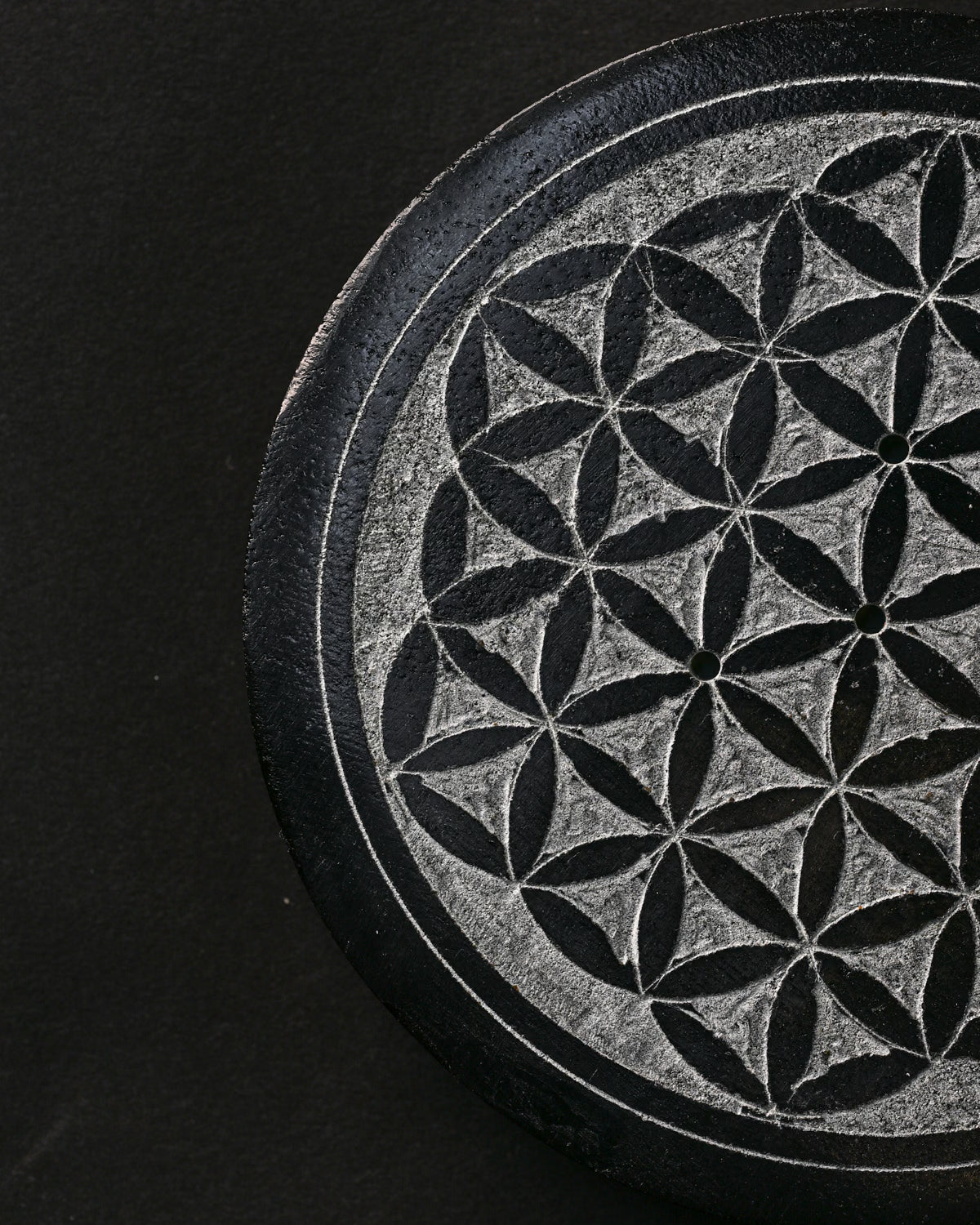 Close view of the Flower of Life pattern carved into the stone incense holder.