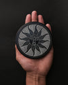 Soleil Noir carved stone incense holder resting on an open palm.