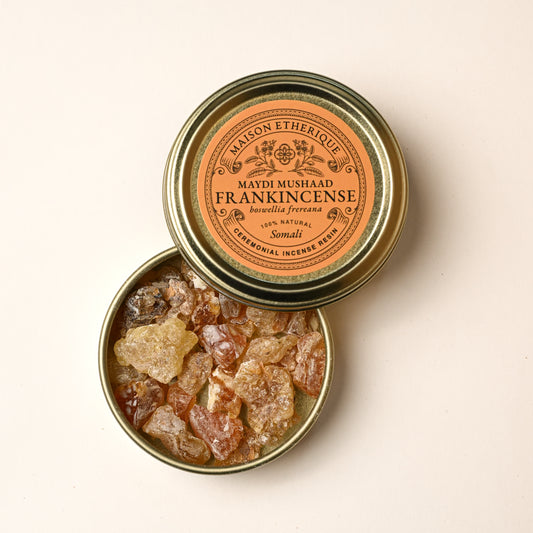 Open gold tin of Maison Éthérique Maydi Mushaad frankincense (Boswellia frereana) from Somalia, amber resin pieces visible inside.