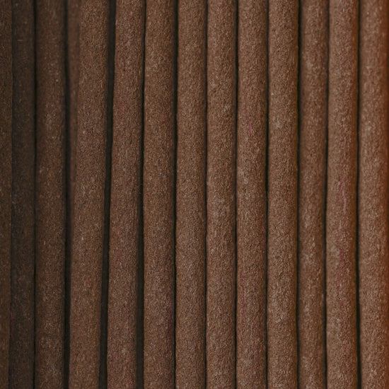 Close view of Na Swa incense sticks laid side by side, showing their brown texture.