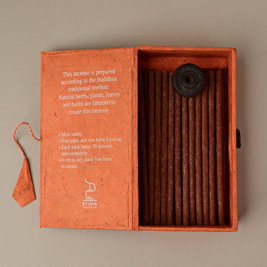 Open orange paper box of Stupa Na Swa incense sticks from Nepal, the sticks and a small holder visible inside.
