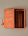 Open orange paper box of Stupa Na Swa incense sticks from Nepal, the sticks and a small holder visible inside.