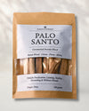 Front of a kraft pouch of Maison Éthérique Palo Santo, 100 g, sticks visible through a clear window, on a pale background.