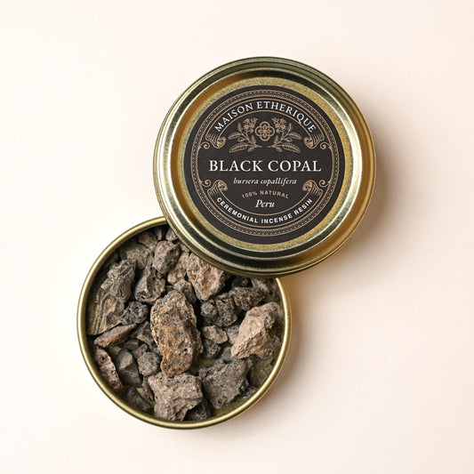 Open gold tin of Maison Éthérique Black Copal (Bursera copallifera) from Peru, grey resin pieces visible inside.