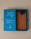 Open blue paper box of Stupa Sandalwood incense sticks from Nepal, the sticks and a small holder visible inside.