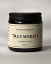 Amber glass jar of Maison Éthérique True Myrrh (Commiphora myrrha) from Yemen, black lid, on a pale background.