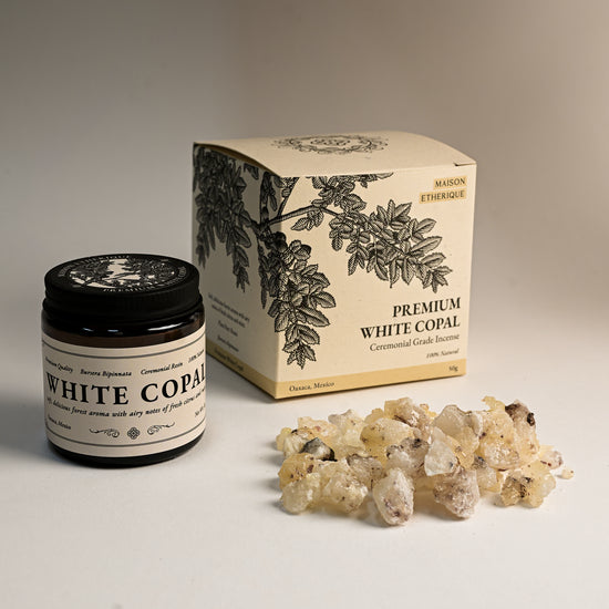 Amber jar and illustrated box of Maison Éthérique Premium White Copal beside a small heap of pale resin pieces.