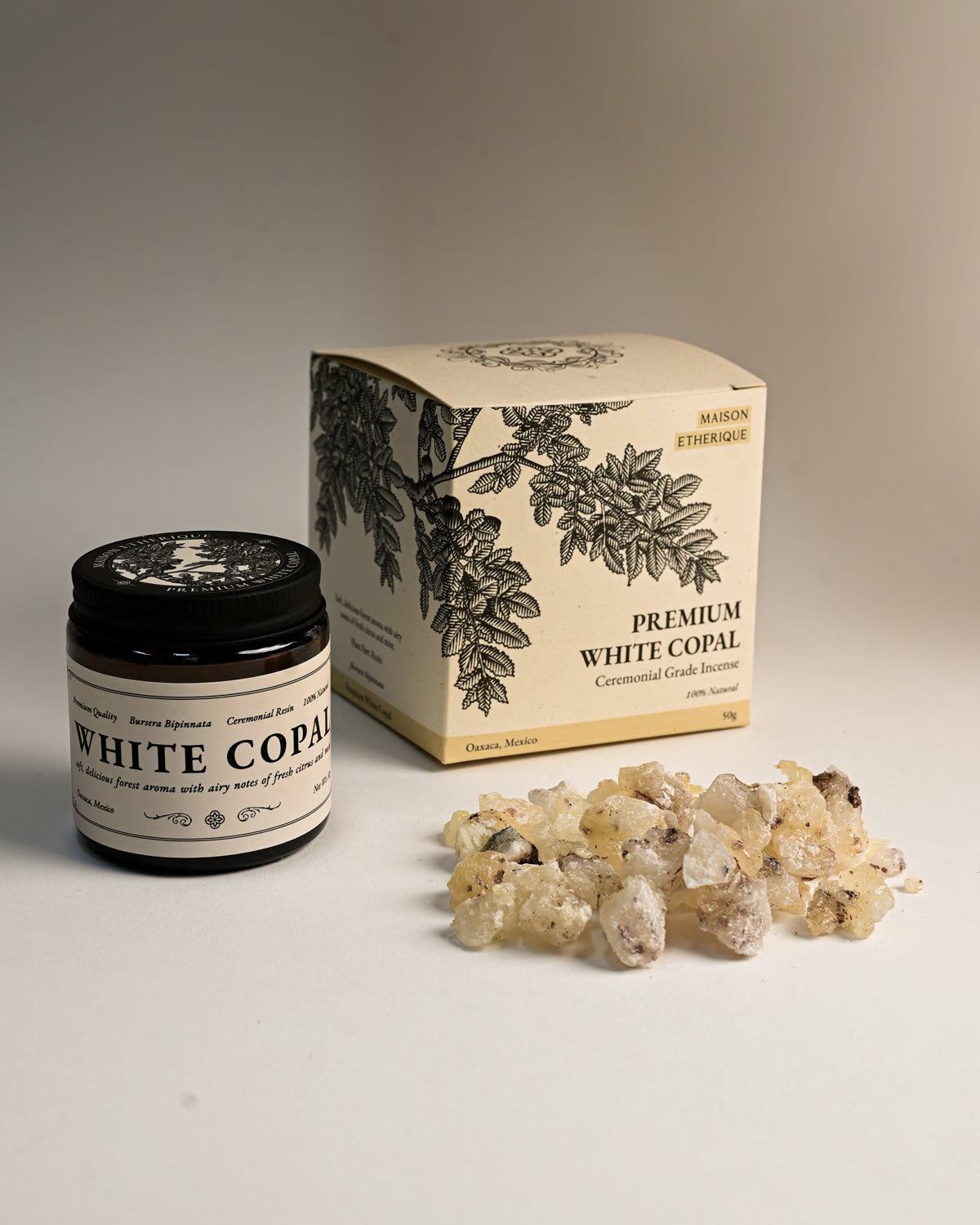 Amber jar and illustrated box of Maison Éthérique Premium White Copal beside a small heap of pale resin pieces.