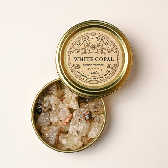 Open gold tin of Maison Éthérique White Copal (Bursera bipinnata) from Mexico, pale resin pieces visible inside.