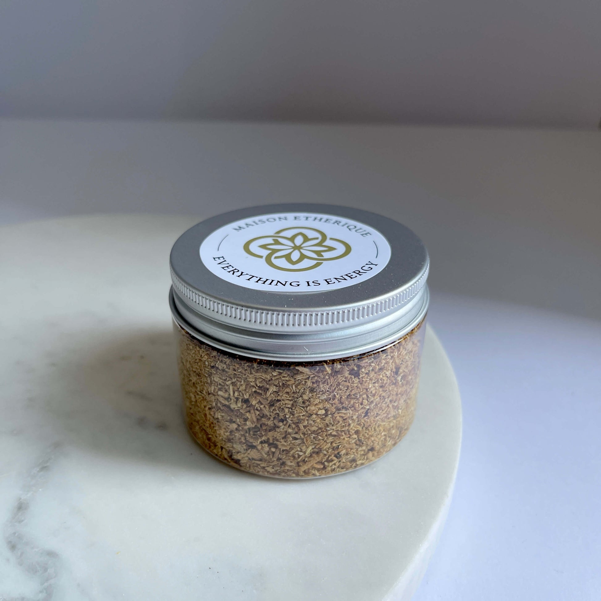 A jar of Palo Santo Powder on a marble wedge